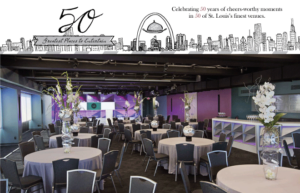 A decorated event space with round tables and chairs, featuring tall floral centerpieces. The banner above celebrates "50 Greatest Places to Entertain" in St. Louis, with an illustration of the city's skyline.