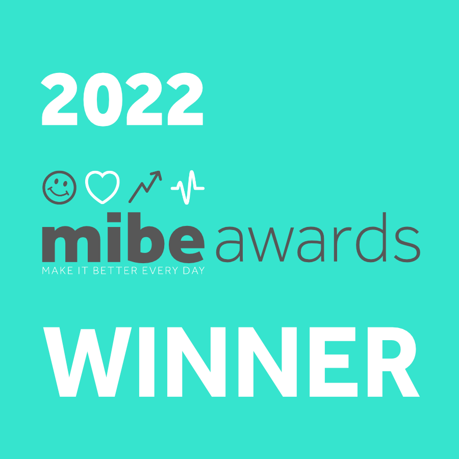 The teal image displays "2022 mibe awards" with the text "Make It Better Every Day" beneath it. The words "WINNER" are prominently featured at the bottom. Icons of a smiley face, heart, and upward arrow are also included.